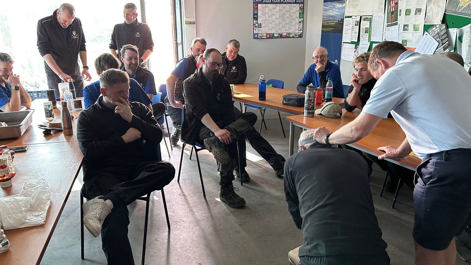 David Sulivan guides Royal Dornoch course manager Eoin Riddell on CPR, with fellow greenkeepers looking on.