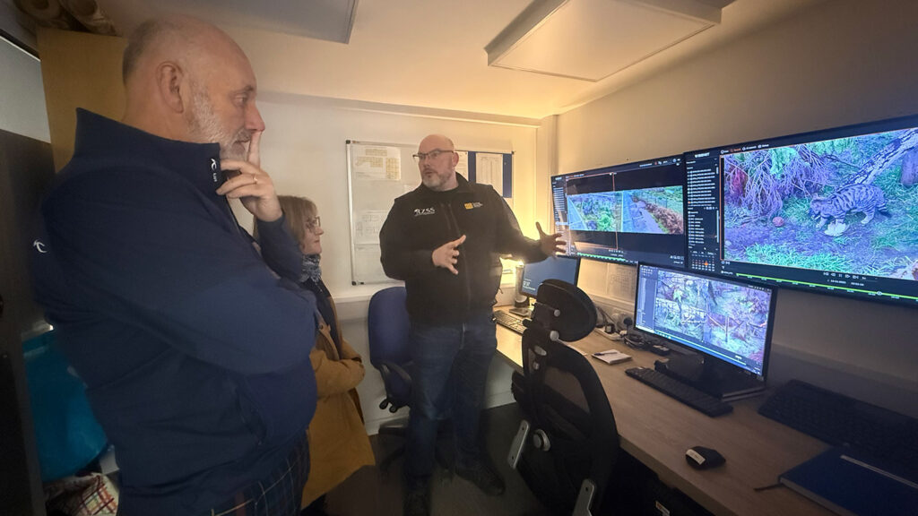 Gary and his wife Debbie listen as David Barclay discusses live footage of the wildcat kitten christened “Dornoch”